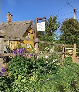The thatched cottage and Old School Cattery sign on Old School Road, Whepstead, near Bury St Edmunds